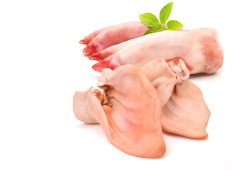 Two raw pig feet behind two raw pig ears